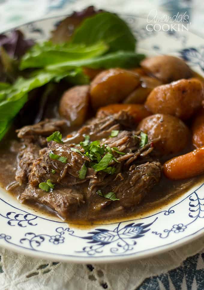 crockpot roast beef with carrots and salad on a plate