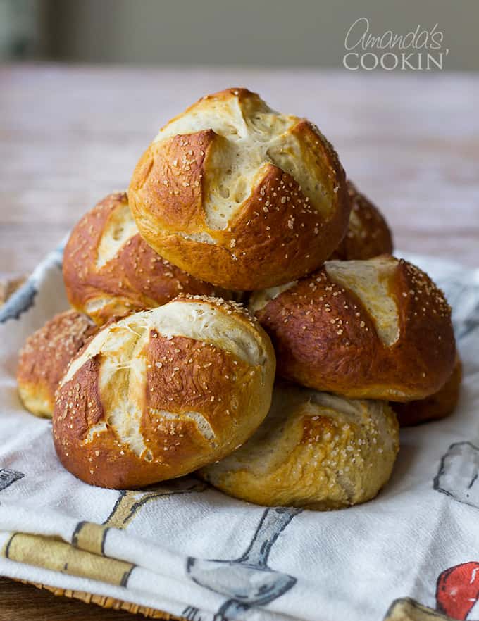 A stack of baked bretzel rolls laying on a towel.