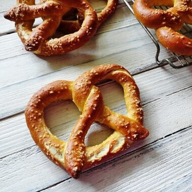 A close up overhead of a homemade German pretzel with more in the background.
