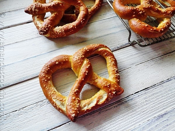 A close up overhead of a homemade German pretzel with more in the background.
