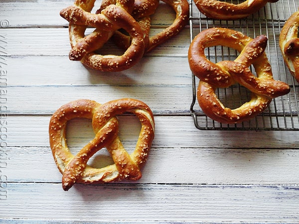 An overhead of homemade German pretzels on a cooling rack.