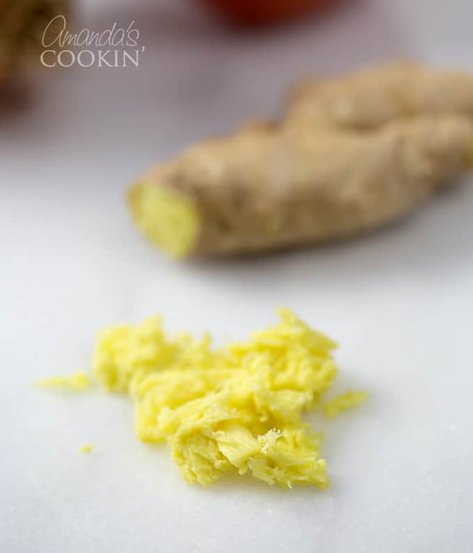 Chopped fresh ginger on a white cutting board.