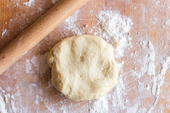 ball of pizza dough with rolling pin