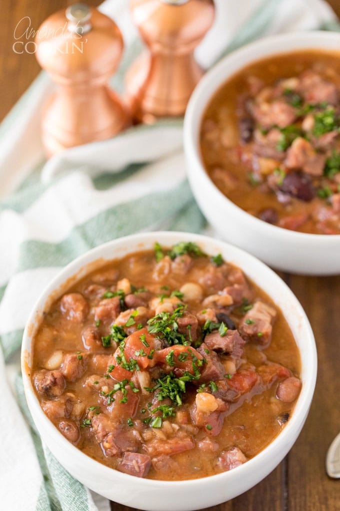 two bowls and ham and bean soup with parsley garnish