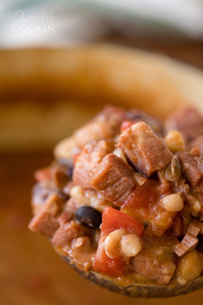close up photos of a ladle full of ham and bean soup