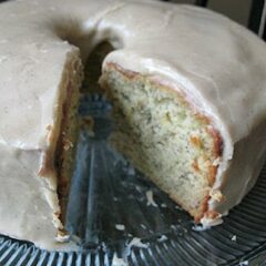 A close up photo of a bananas and cream Bundt cake with brown butter glaze with a slice removed.