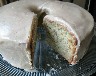 A close up photo of a bananas and cream Bundt cake with brown butter glaze with a slice removed.
