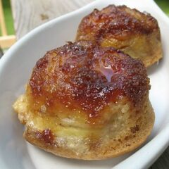 Banana upside down muffins in a white bowl.