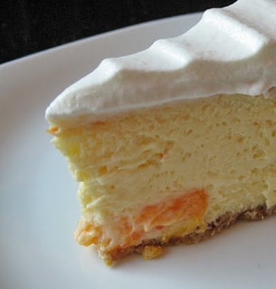 A close up photo of a slice of mandarin orange cheesecake on a plate.