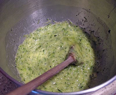 An overhead photo of a bowl of zucchini, oil, eggs, and vanilla.