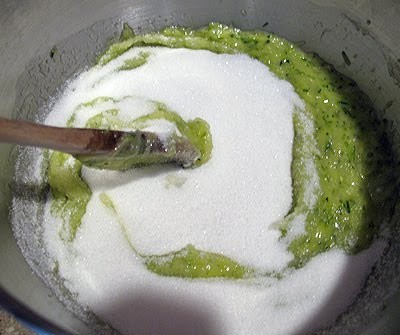 An overhead photo of a bowl of zucchini, oil, eggs, vanilla and sugar.