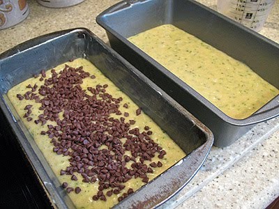 A photo of two loaf pans filled with morning glory zucchini bread batter.