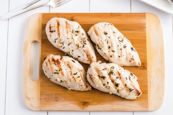 cooked grilled chicken on a cutting board