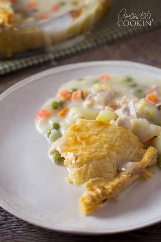 A close up of a serving of homemade pot pie on a white plate.