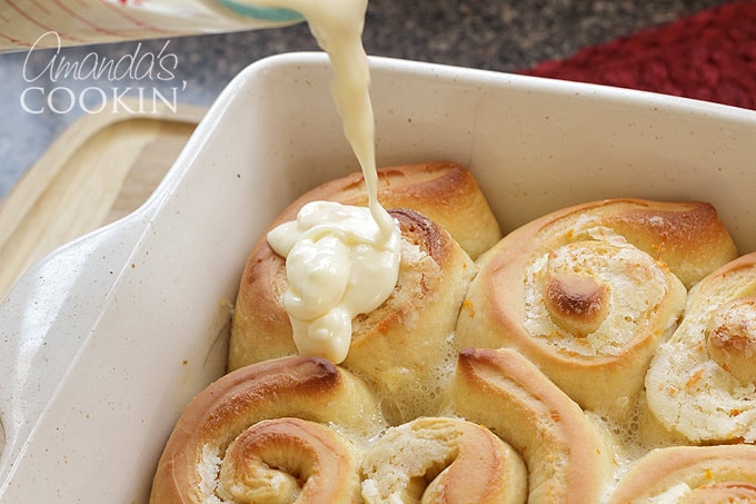 adding frosting to orange rolls