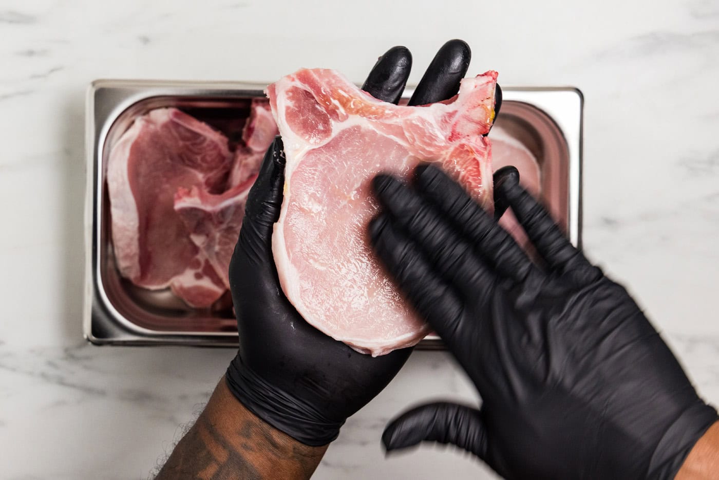rubbing olive oil on pork chop