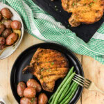 Grilled Breaded Pork Chops on a platter with one plated with sides