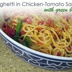 A close up photo of a bowl of spaghetti in chicken tomato sauce with green beans.