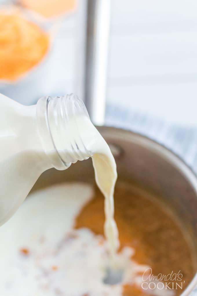 pouring milk into mac and cheese