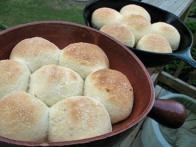 A close up photo of homemade dinner rolls in two cast iron skillets.