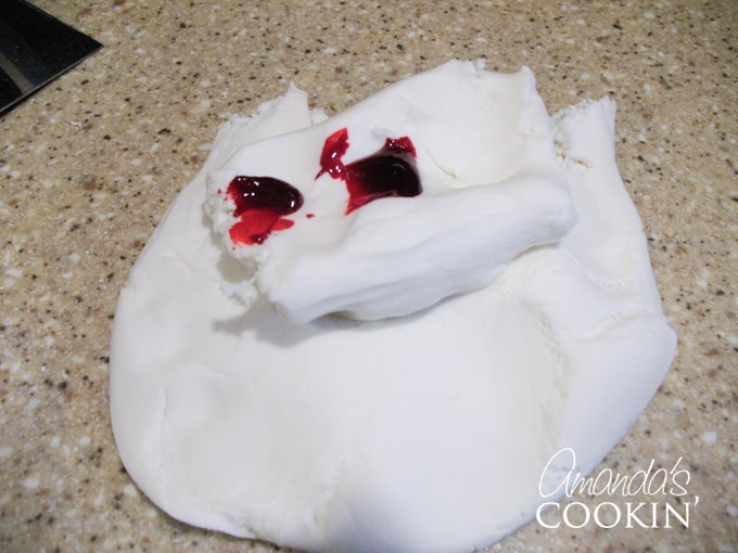 A photo of white fondant with red food coloring on top.