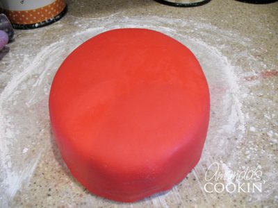 A photo of a a cake covered in red fondant.