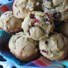 Pumpkin cranberry muffins with white chocolate chunks resting in a bowl.