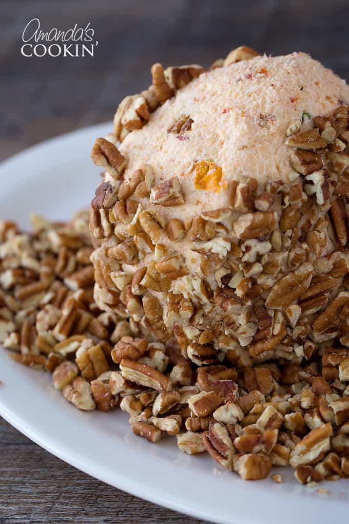 cheese ball being covered with chopped nuts