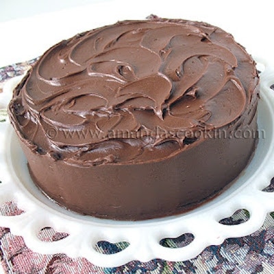 A Nigella's old fashioned chocolate cake resting on a white cake stand.