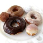 A photo of a plate of an assortment of homemade doughnuts.