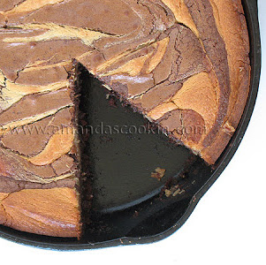 An overhead photo of a peanut butter marbled brownie skillet pie with a slice removed.