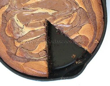An overhead photo of a peanut butter marbled brownie skillet pie with a slice removed.