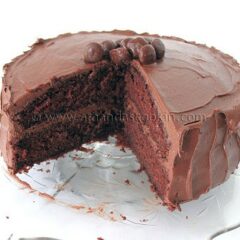 A close up photo of a nigella's chocolate fudge cake with a big slice removed.