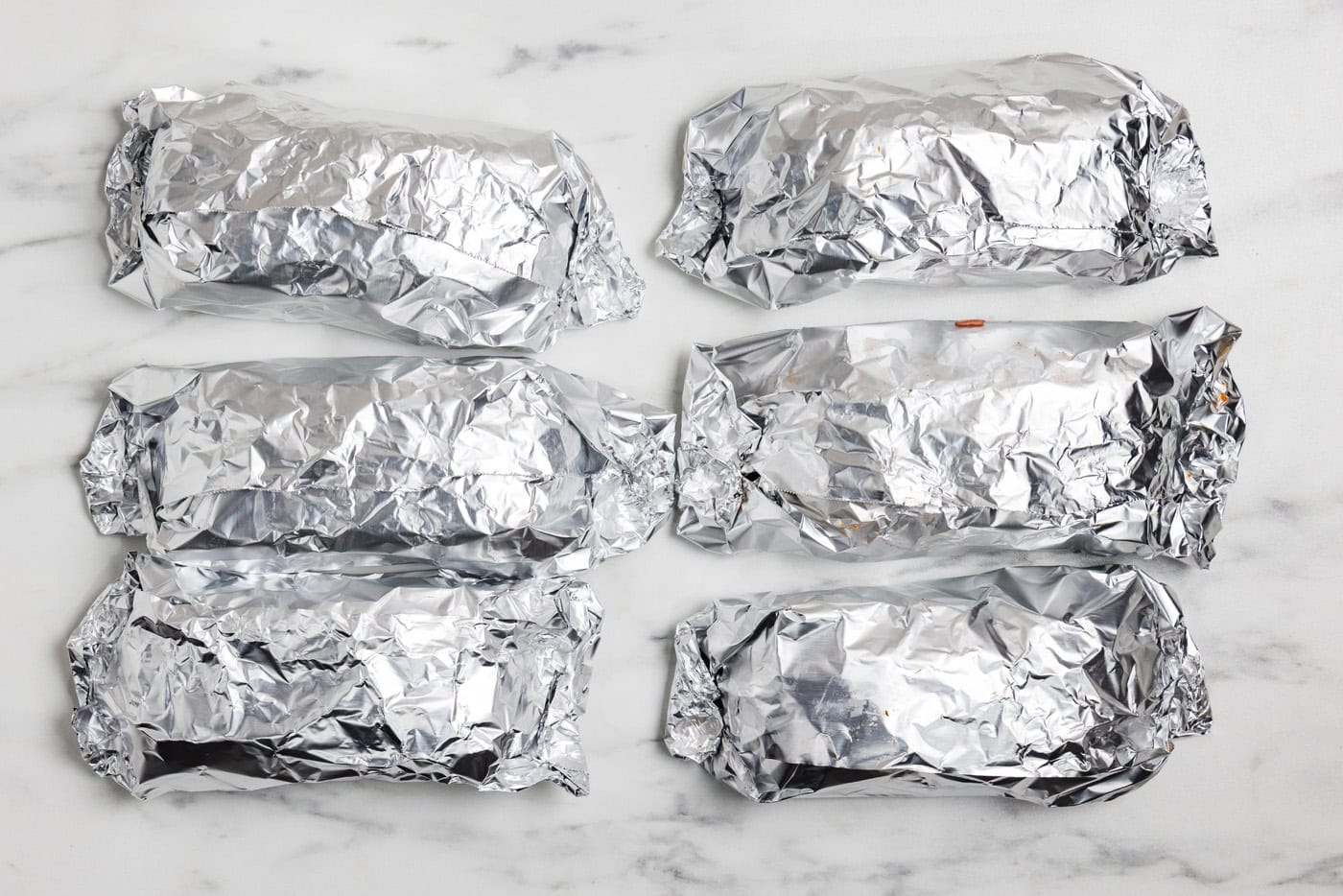 sandwiches wrapped in foil ready for the oven