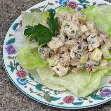 A photo of chicken salad on a piece of lettuce.