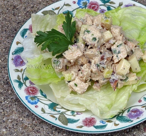A photo of chicken salad on a piece of lettuce.