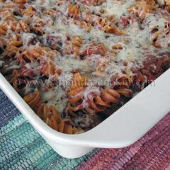 A close up photo of baked rotini with Italian sausage in a baking dish.