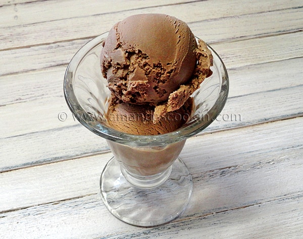 A close up photo of root beer ice cream in a clear bowl.