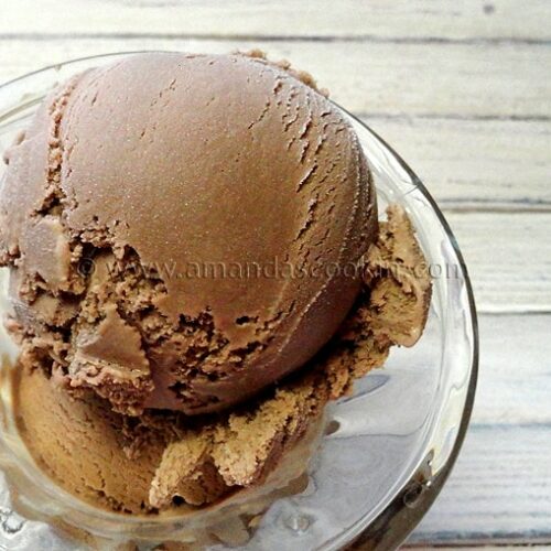 A close up photo of root beer ice cream in a clear bowl.