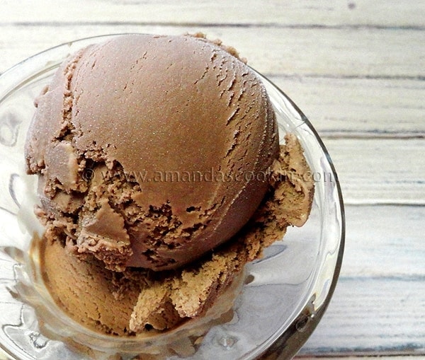 A close up photo of root beer ice cream in a clear bowl.