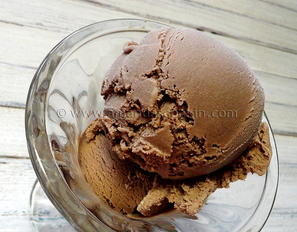 A close up photo of root beer ice cream in a clear bowl.