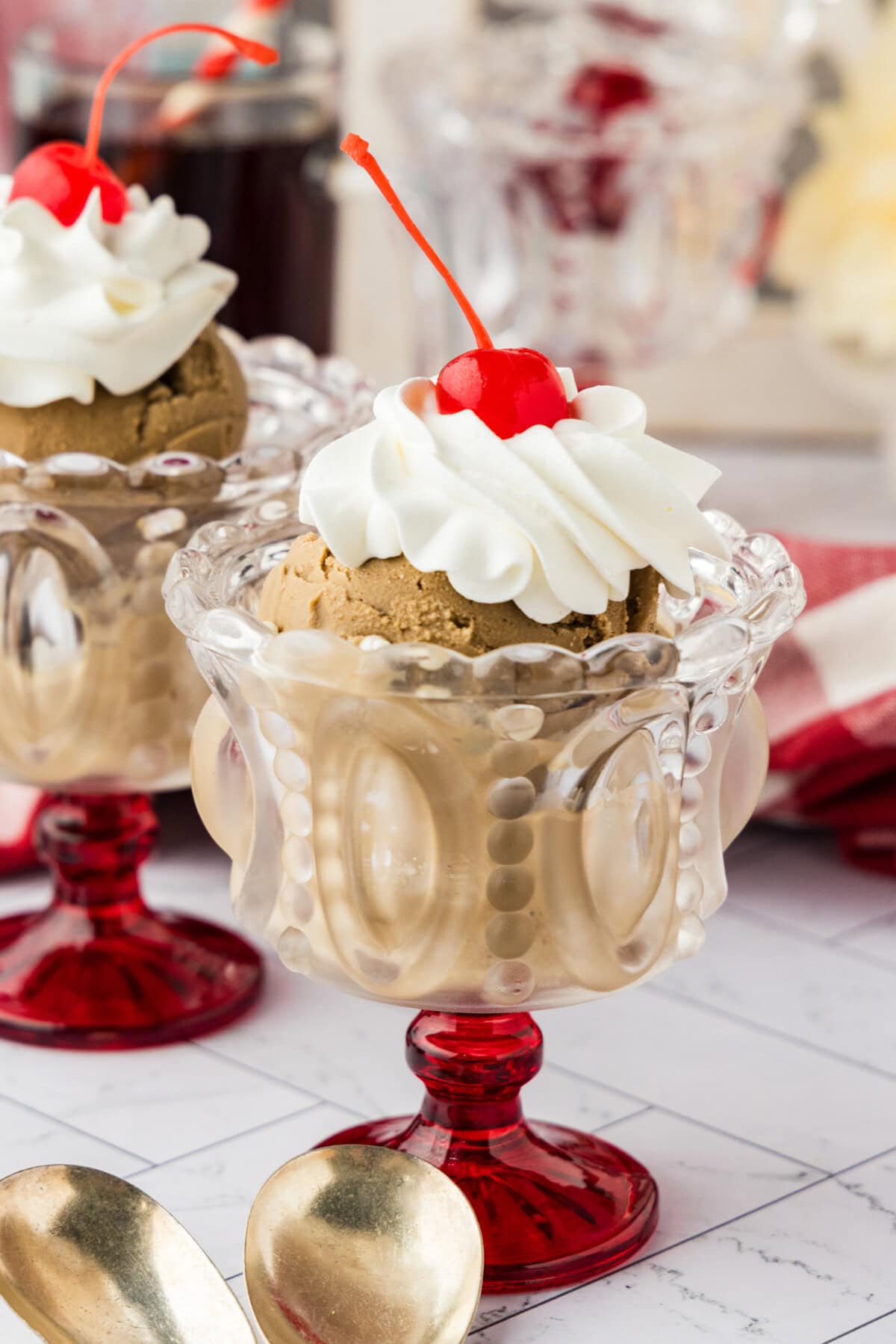 glass dessert dishes of homemade Root Beer Ice Cream with whipped cream and a cherry