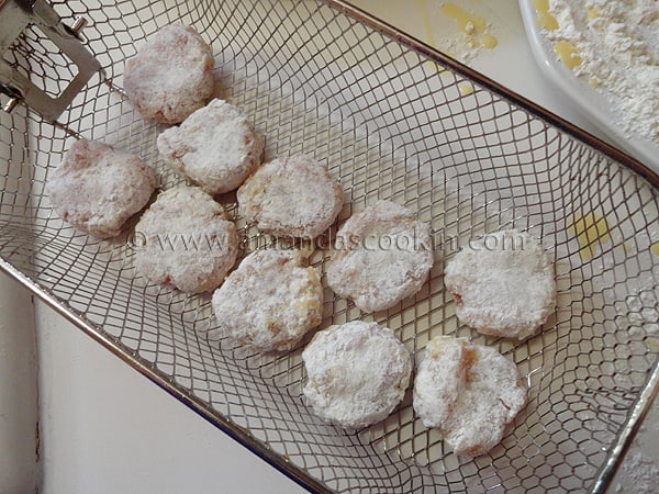 A photo of raw chicken nuggets in a frying basket.