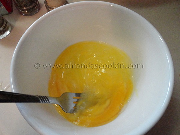 A white bowl filled with whisked eggs