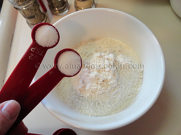 A photo of salt being added to flour in a bowl.