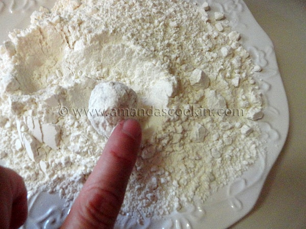 A photo of chicken ball being rolled in flour.