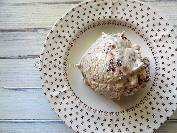 A close up overhead photo of a scoop of Nutella swirl cheesecake ice cream on a plate.