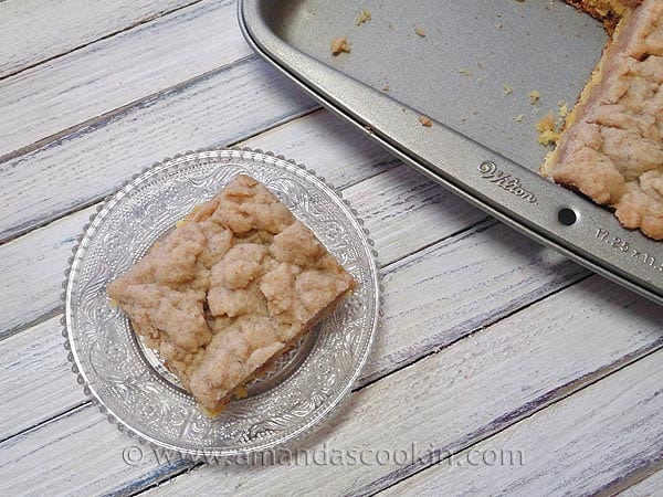 An overhead photo of a piece of crumb cake on a clear plate.