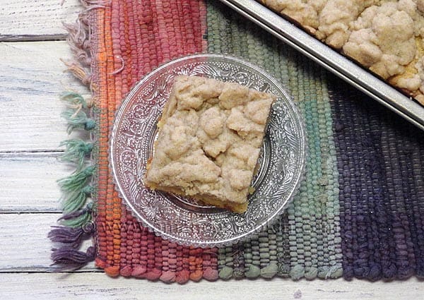 An overhead photo of a piece of crumb cake on a clear plate.