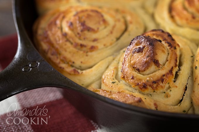 A close up of Parmesan garlic rolls freshly baked in a round pan.